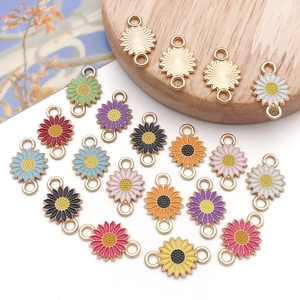Close-up of colorful daisy enamel charms with double loops for DIY jewelry making