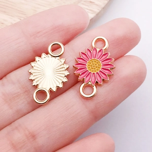 Detailed macro view of pink enamel daisy charm with golden metal textured back