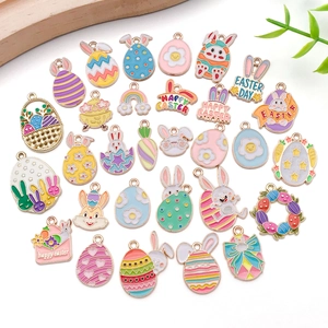 Variety of colorful Easter enamel charms with bunnies and eggs on white background