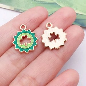 Macro view of green enamel shamrock charms with rose gold gear edges for DIY jewelry making