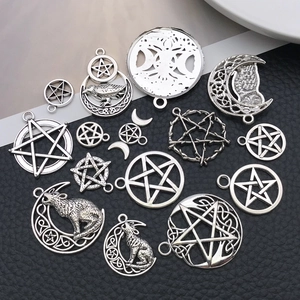 Detalle de dijes de plata vintage con diseños de pentagrama hueco, lobo y búho