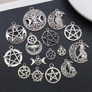Vista detallada de colgantes antiguos de plata con motivos de pentagrama, búho y lobo