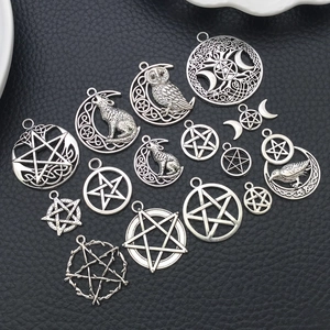 Detalle de colgantes vintage de plata con pentagrama y búho sobre cuero negro