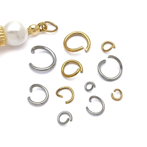 Detailed view of assorted gold and silver jump rings with a decorative pearl connector