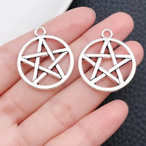 Primer plano de un dije de pentagrama en aleación de plata antigua con textura metálica