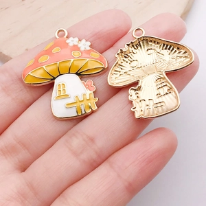 Detail of mushroom alloy pendant with orange spotted cap and golden metal texture