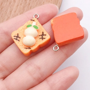 Detailopname van mini broodbedeltjes van hars met metalen ringen voor DIY-sieraden