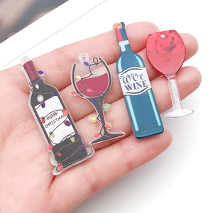 Macro view of four acrylic wine bottle and goblet pendants for DIY jewelry making