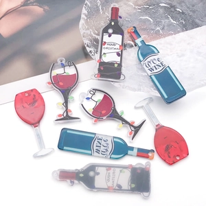 Macro shot of acrylic Christmas wine bottle and glass charms with Merry Christmas prints