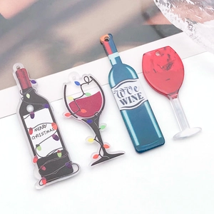 Detail of acrylic wine bottle and goblet pendants with Merry Christmas text for DIY jewelry