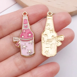 Detail von rosa Emaille-Flaschenanhängern und Goldmetallsockeln für DIY-Schmuck