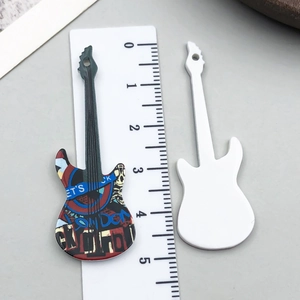Dettaglio di ciondoli a chitarra in acrilico con motivi rock e righello per misure