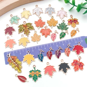 Mix of colorful maple leaf alloy charms for DIY jewelry with ruler for size reference
