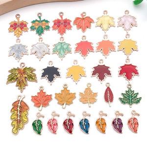 Detailed view of colorful enamel autumn leaf charms with maple and oak designs for jewelry