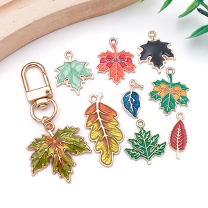 Detailed macro view of colorful enamel maple leaf charms and gold alloy pendants