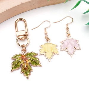 Detail of colorful enamel maple leaf charms with golden hooks for DIY jewelry making
