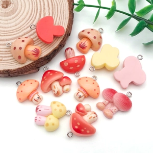 Detailaufnahme bunter Harz-Pilzanhänger mit Silberösen für DIY-Schmuck und Bastelprojekte