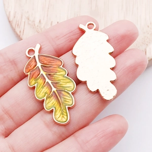 Detail of enamel maple leaf pendants showing front gradient and back gold-tone finish