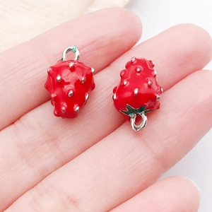 Detail of red strawberry enamel charms with silver seeds for DIY jewelry making