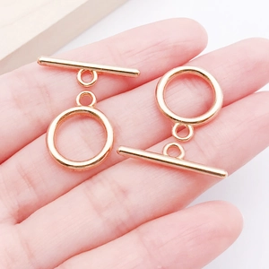 Mini gold-plated alloy OT toggle clasp connectors for DIY jewelry making shown in hand