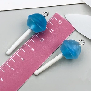 Détail des pendentifs sucettes en résine bleue avec une règle indiquant la taille 55mm
