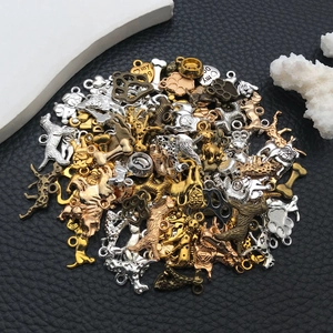 Détail de breloques pour chiens en métal avec motifs d'os et pattes sur cuir noir