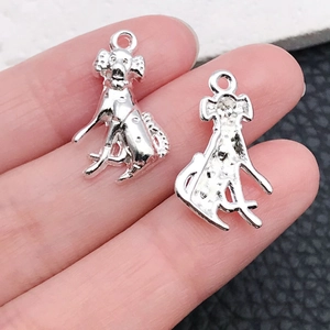 Detailed view of silver poodle alloy charms for DIY jewelry making held in hand