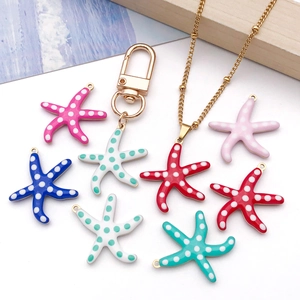 Colorful starfish enamel charms with gold clasps shown on wave texture background