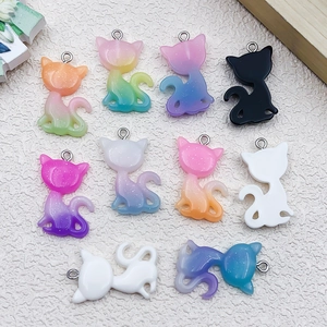 Macro shot of colorful glitter resin cat pendants with silver metal rings for DIY jewelry