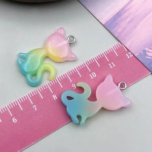 Macro detail of cat-shaped glitter resin pendants with iridescent gradient and metal rings