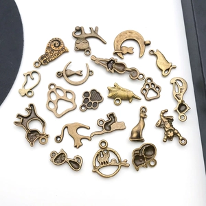 Detailweergave van vintage bronzen katten- en pootbedeltjes voor DIY-sieraden