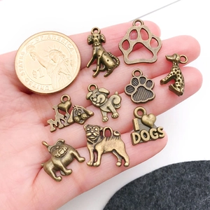 Gros plan de breloques chien en bronze vintage dans la main avec une pièce pour la taille