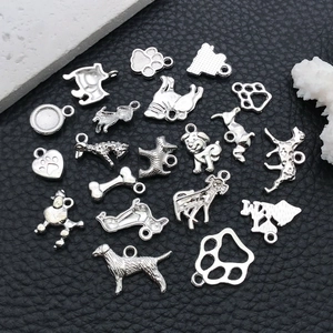 Detailed macro view of assorted silver dog charms and paw prints for DIY jewelry making