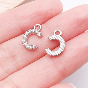 Macro shot of silver C-letter pendants with rhinestones for DIY jewelry making