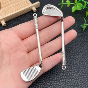 Dettagli di due ciondoli a mazza da golf in argento con texture a lisca di pesce e anello