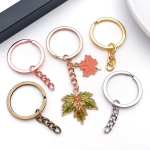 Close-up of assorted metallic keyrings with intricate enamel maple leaf pendants and chains