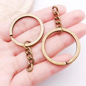 Close-up of bronze-plated keychain rings with durable 4-link chains in a hand view