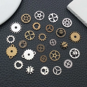 Flat lay of mixed steampunk alloy gears in bronze, silver and gold on black leather