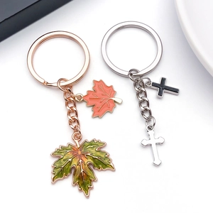 Metal keychains with maple leaf and cross pendants in rose gold and silver finishes