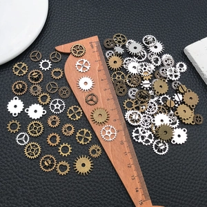 Assorted steampunk metal gear charms for DIY crafts on a textured leather background
