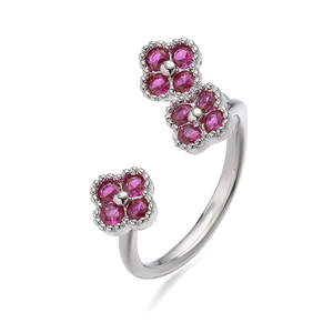Detail van verstelbare zilveren ring met drie klavertjes en roze steentjes