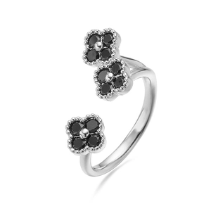 Detail van een verstelbare zilveren ring met drie klavertjes vier en zwarte edelstenen