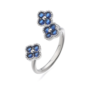 Macro-detail van de verstelbare zilveren ring met drie fonkelende blauwe klaverhangers