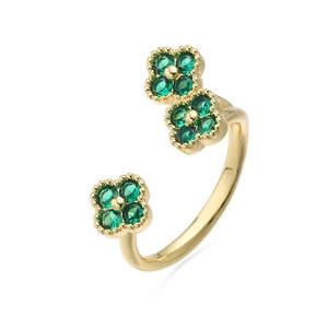Detail van verstelbare gouden ring met drie groene zirkoon klavertjes en kralenranden