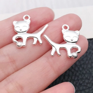 Nahaufnahme von silbernen Katzenanhängern für DIY-Schmuck auf Texturhintergrund