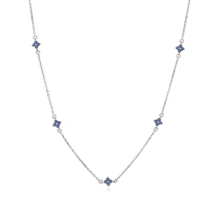Dettaglio macro della collana d'argento con cinque pendenti a quadrifoglio blu scuro