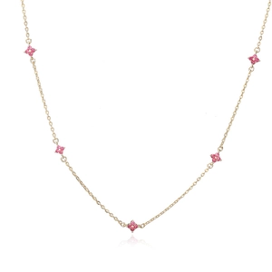Dettaglio di una collana dorata con cinque ciondoli a quadrifoglio in zircone rosa