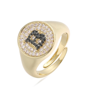 Detalle del anillo letra B con circonitas blancas y negras sobre banda dorada de sello