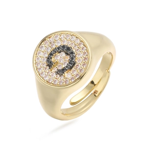 Detalle macro del anillo de herradura dorado con circonitas negras y blancas