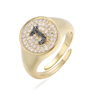 Primer plano detallado de un anillo de sello dorado con la letra J de circonitas brillantes